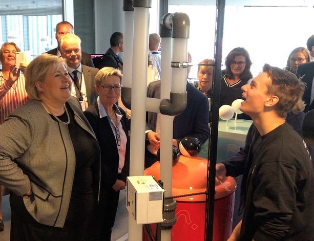 Mennesker rundt et rørsystem