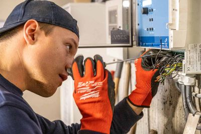 Ansatt skrur på et elektrisk anlegg